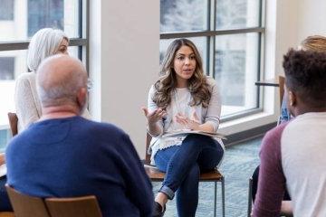 Woman addresses group in counseling session.